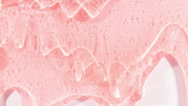 Pink Transparent Cosmetic Gel Fluid With Molecule Bubbles Flowing On The Plain White Surface. Macro Shot. High quality 4k footage
