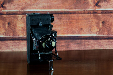 Antique Folding Camera on a Varnished Wooden Shelf