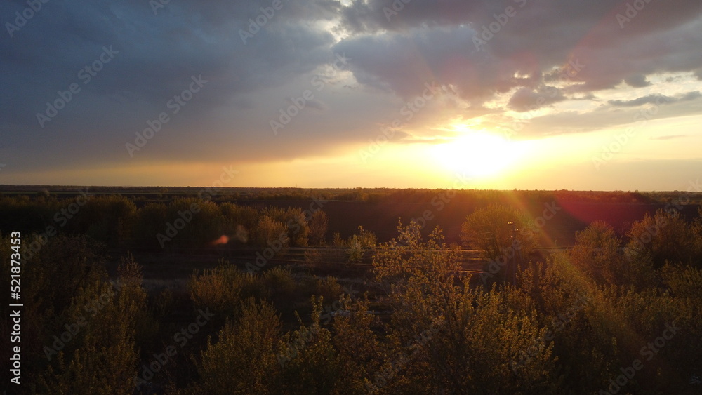 Poster sunset, clouds and fields from a height in summer.