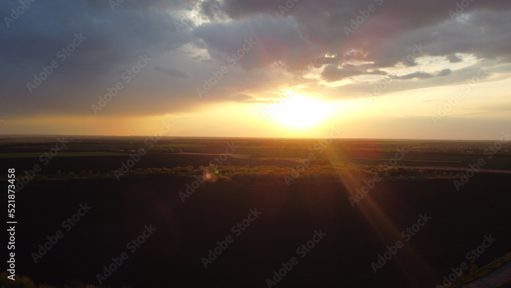 Poster sunset, clouds and fields from a height in summer.