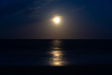 Beach at night with moon in sky