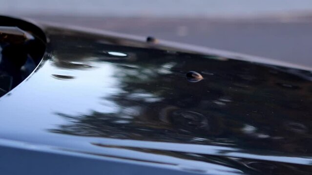 Damaged car engine hood with many hail damage dents show the importance of car insurance and a replacement value insurance against stormy weather storm hazards or extreme weather hail storms blizzards