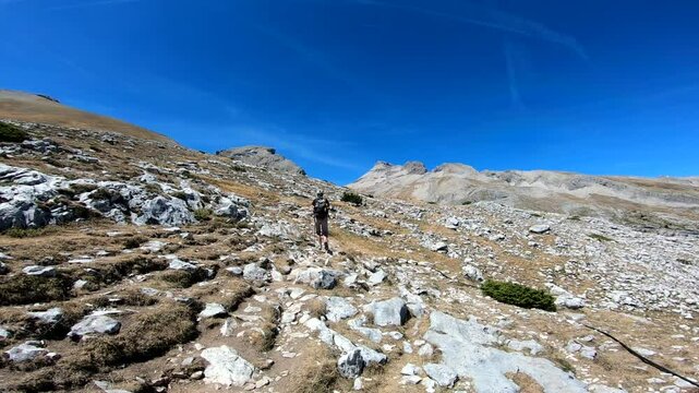 Woman hike with hand sticks Stony dry environement Grand Ferrand peak