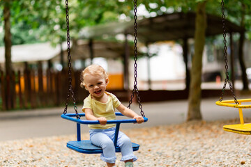 Blurred happy girl in motion swinging on a swing