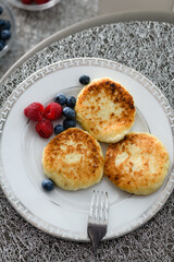 Cottage cheese pancakes with blueberries and raspberries and sour cream.