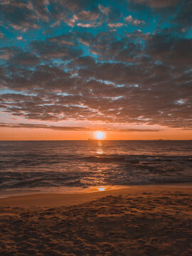 Nascer do sol no mar de Vila Velha no Espírito santo. Céu dourado e azul e reflexo do sol no mar. © rafa