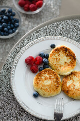 Cottage cheese pancakes with blueberries and raspberries and sour cream.