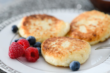 Close-up of cottage cheese pancakes with blueberries and raspberries.