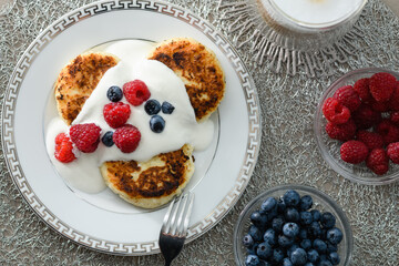 Top view of cottage cheese pancakes with blueberries and raspberries.