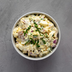 Homemade Healthy Potato Salad with Eggs in a Bowl on a gray surface, top view. Flat lay, overhead, from above.