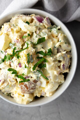 Homemade Healthy Potato Salad with Eggs in a Bowl on a gray surface, top view. Flat lay, overhead,...