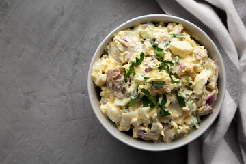Homemade Healthy Potato Salad with Eggs in a Bowl on a gray surface, top view. Flat lay, overhead, from above. Space for text.