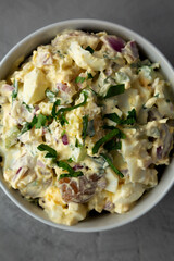 Homemade Healthy Potato Salad with Eggs in a Bowl on a gray background, top view. Flat lay, overhead, from above. Close-up.