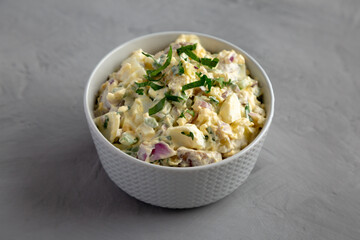 Homemade Healthy Potato Salad with Eggs in a Bowl on a gray background, side view.