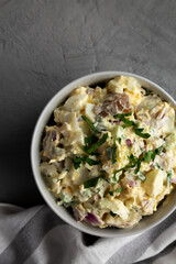 Homemade Healthy Potato Salad with Eggs in a Bowl on a gray background, top view.