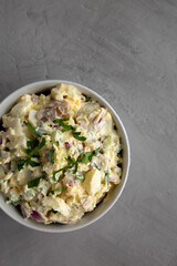 Homemade Healthy Potato Salad with Eggs in a Bowl on a gray background, top view. Flat lay, overhead, from above. Copy space.