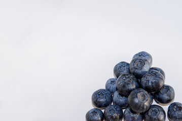 Blueberries are scattered on a white background. Fresh garden blueberries close-up.