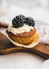 muffin cupcake paper mold carrot cake topped with whipped cream and berries 
blackberry