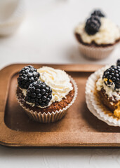 muffin cupcake paper mold carrot cake topped with whipped cream and berries 
blackberry