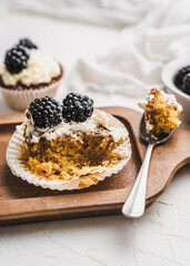 muffin cupcake paper mold carrot cake topped with whipped cream and berries 
blackberry
