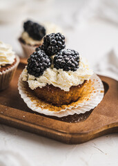 muffin cupcake paper mold carrot cake topped with whipped cream and berries 
blackberry