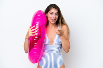 Young woman in swimsuit holding an air mattress donut isolated on white background surprised and...