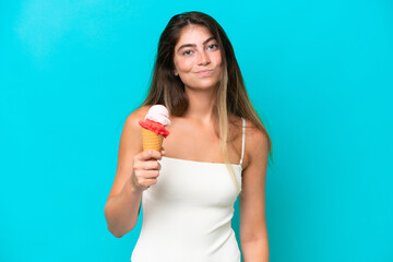 Young woman in swimsuit holding an ice cream isolated on blue background with sad expression
