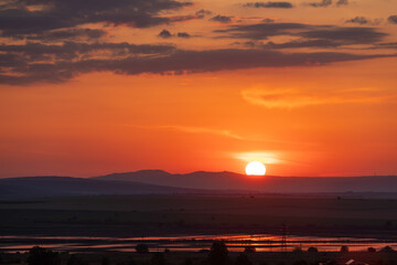 Fototapeta Zachód słońca w Bułgarii. Pomarańczowe niebo z lekkimi chmurami. Krajobrazy letnie. obraz