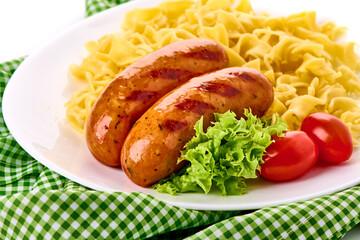 Barbecued pork bangers with pasta. Cooked sausages bbq.