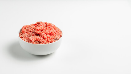 Plate with fresh ground beef on a white background, space for text