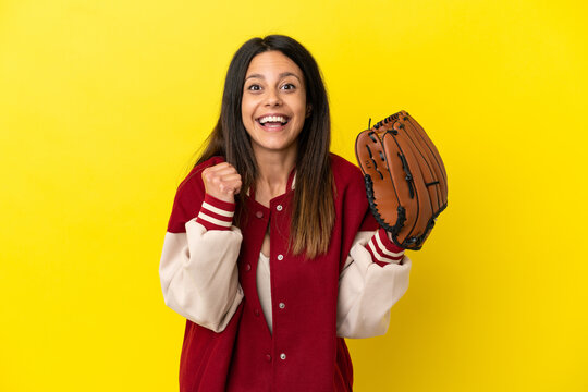 Young caucasian woman playing baseball isolated on yellow background celebrating a victory in winner position