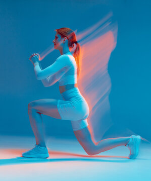 Fitness girl does squats with lunges, exercises for fit buttocks, hips. Long exposure, motion blur. Sports workout