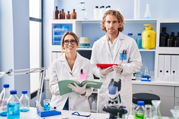 Two people working at scientist laboratory smiling with a happy and cool smile on face. showing teeth.