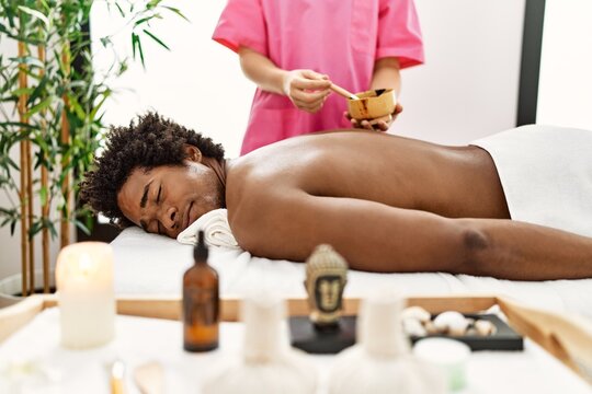 Young african american man having skin back treatment at beauty center