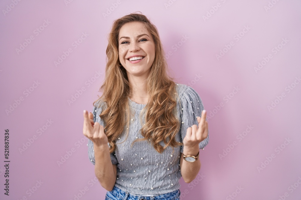 Poster Beautiful blonde woman standing over pink background showing middle finger doing fuck you bad expression, provocation and rude attitude. screaming excited