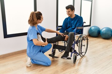 Young disabled man making mobility exercise sitting on wheelchair at the clinic.