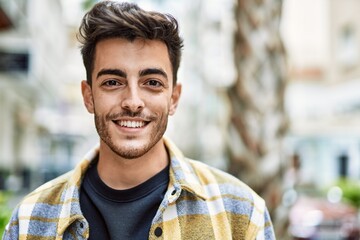Fototapeta premium Handsome hispanic man smiling happy and confident at the city