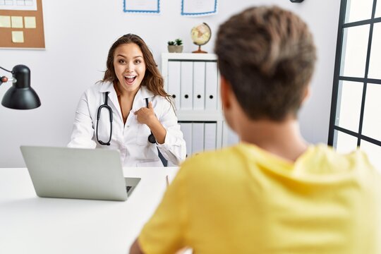 Young Doctor Woman With Patient At The Clinic Pointing Finger To One Self Smiling Happy And Proud