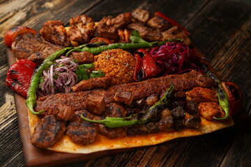 Turkish traditional mixed kebab on wooden plate. Turkish and Arabic Traditional Mix Kebab Plate include Adana, Urfa, Chicken, Lamb, Liver and Beef with thin bread. Tradition food and bread. 