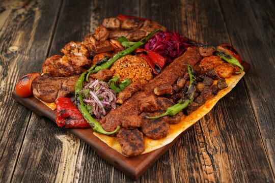 Turkish traditional mixed kebab on wooden plate. Turkish and Arabic Traditional Mix Kebab Plate include Adana, Urfa, Chicken, Lamb, Liver and Beef with thin bread. Tradition food and bread. 