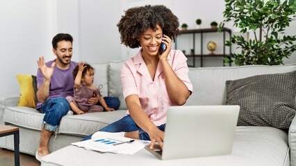 Couple and daughter smling confident and woman working at home