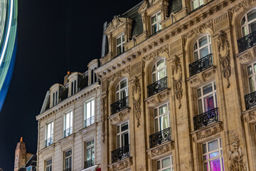 old style french town hall in european town at night with colors