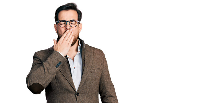 Young hispanic man wearing business jacket and glasses bored yawning tired covering mouth with hand. restless and sleepiness.