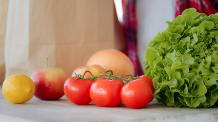 Close up female hands takes purchases refresh nutriment products in bags from grocery ecological supermarket. Unknown housewife vegetarian buyer unpacks natural vegetables apples tomatoes salad citrus