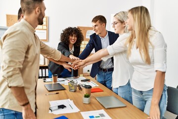 Obraz premium Group of business workers smiling happy celebrating with hands together at the office.