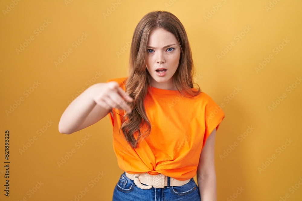 Poster Caucasian woman standing over yellow background pointing displeased and frustrated to the camera, angry and furious with you