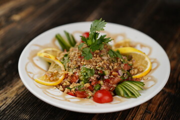 Finely chopped Turkish salad on a wood background. Salad with lemon and parsley. Salad made with fresh vegetables. 