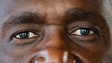 Extreme close up body part human male wrinkled face african american senior elderly adult man with dark iris eyesight masculine person looking at camera with healthy expression ophthalmology service