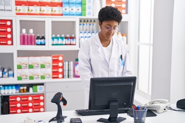 African american woman pharmacist using computer working at pharmacy