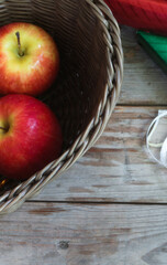Gift box wrapped in bright green and red paper and note book. It is being prepared for delivery, placed on a brown wooden table.